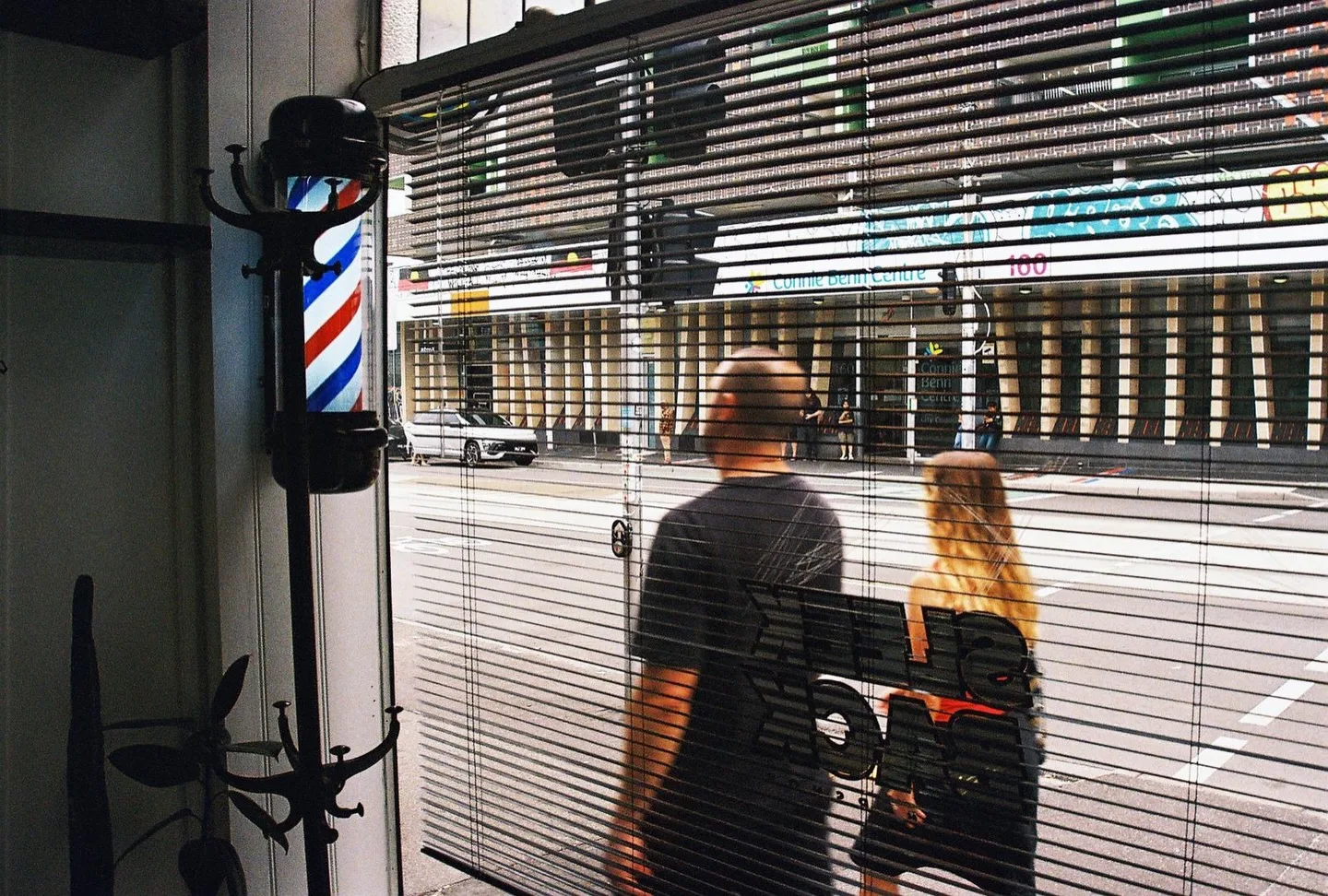 Looking through the shop window to Brunswick Street, barber-pole coat rack visible